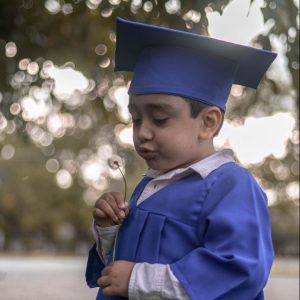 boy in blue academic dress and mortar board