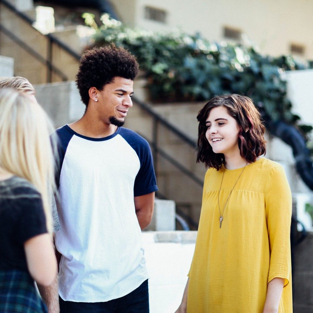 women and man talking outside the building